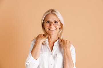 Mature woman in eyeglasses smiling and looking at camera