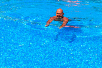 Handsome man relaxing in the swimming pool