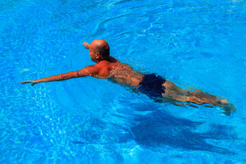 Handsome man relaxing in the swimming pool