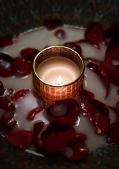 vela encendida en bandeja con pétalos de rosas en el festival Indio de las luces Diwali
