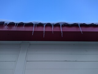icicles hang from the roof of the building.