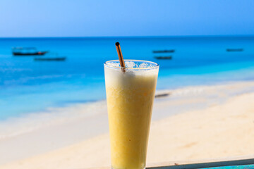 Glass of fresh juice by the ocean. Tropical vacations concept