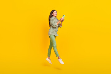 Full size profile side photo of young lady use cellphone post comment connection 4g jump isolated over yellow color background