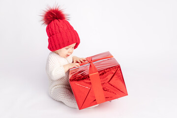 the kid with the red hat and gift on white isolated background, space for text, concept of new year and Christmas