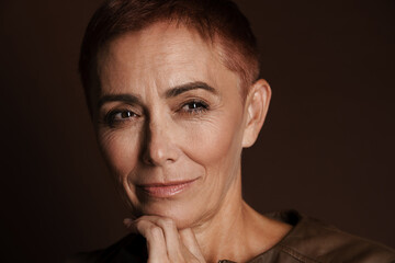 Obraz premium Senior ginger woman with short hair posing and looking aside