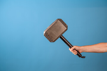 Be a hero, perform a feat. The Scandinavian hammer of Thor, Mjolnir in a man's hand. Photo on a...