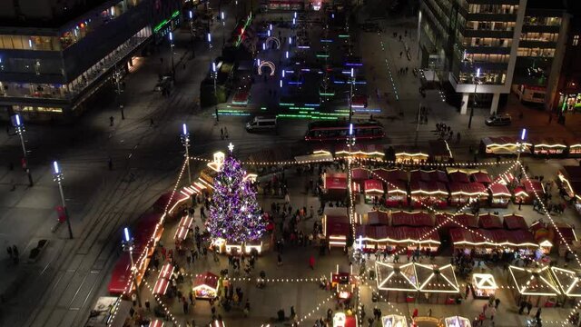 Christmas Market, aerial view. Christmas carousels, an ice rink, a huge decorated Christmas tree and a Ferris wheel.  Illuminated Christmas fair in a modern city.