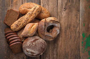 Whole grain, rye and wheat bread on a wooden background.