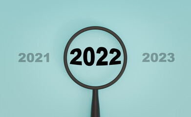 2022 year inside of magnifier glass between 2021 and 2023 on blue background for focus start new business in new year concept by 3d rendering.