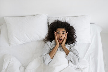 African american woman screaming, lying on bed