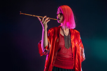 Futuristic look, multicultural outfit, young woman with pink hair in modern trousers, vintage kimono and smoking a pipe in her hands - obrazy, fototapety, plakaty