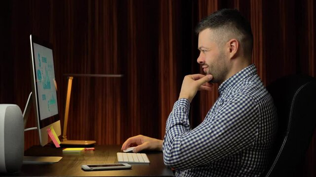 Handsome man working at home on desktop computer