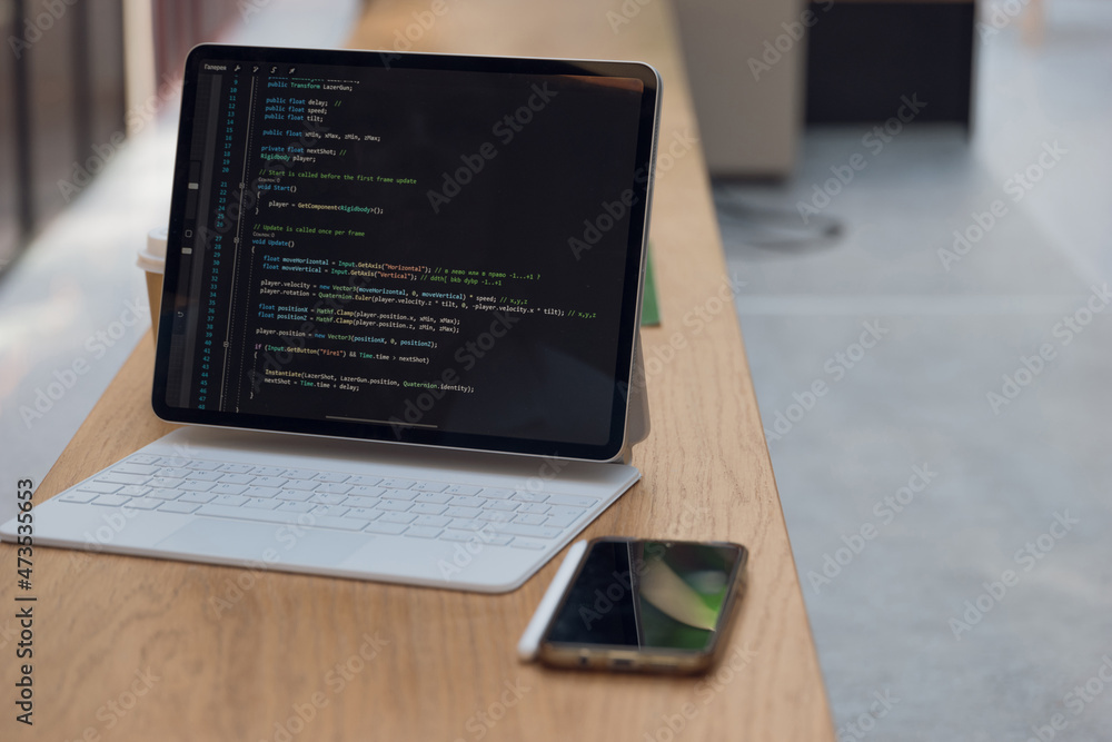 Poster freelancer's workplace. a thin mobile laptop on a table in a coworking or other public space. low de
