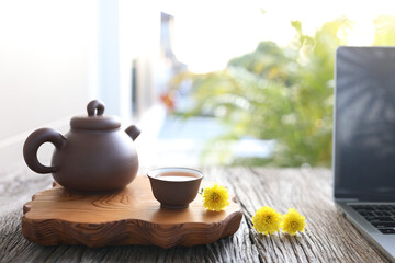 Tea pot and small cup with yellow chrysanthemum flowers