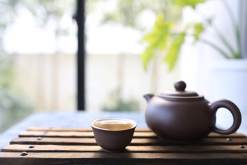 Fototapeta na wymiar earthenware tea cup and tea pot on wooden tray