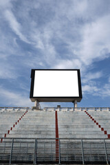 Blank scoreboard with empty seating stand and blue sky background