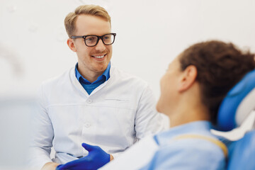 Male dentist having conversation with patient