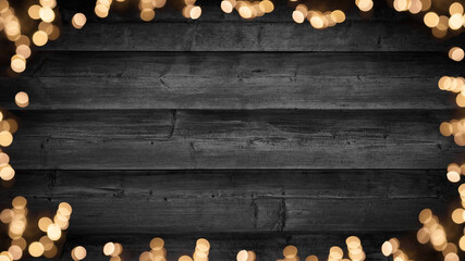 Frame of lights bokeh golden flares, isolated on rustic dark black wooden texture - Christmas...