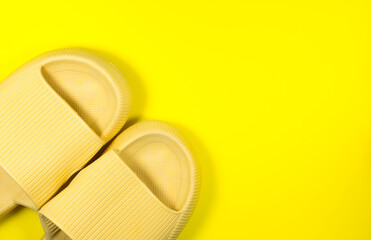 Yellow Summer Slippers on the yellow background. Pair of house indoors shoes. Minimalist, creative photo.