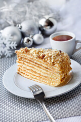 Slice of layered cake on a plate with Christmas balls on the background