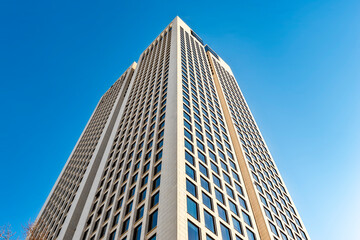 Hochhaus aus der Froschperspektive vor blauem, wolkenlosen Himmel
