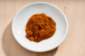 Detailed and large close up shot of powdered paprika on a small plate