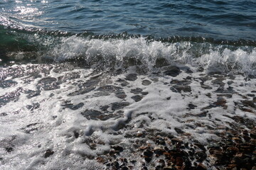 splash of seawave on the beach, foam of the seawave, transparent sea water