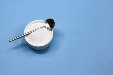 Collagen powder on blue background. Natural health supplement for skin