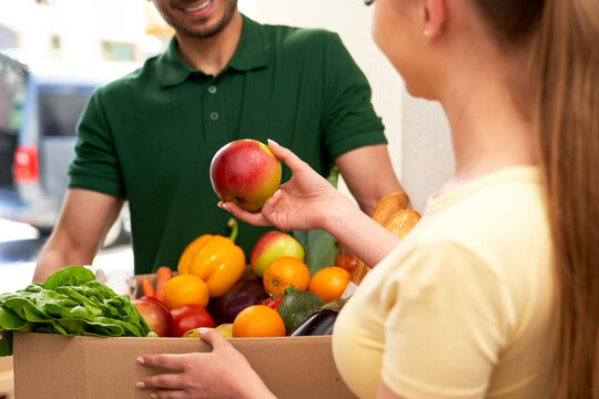 Woman checking fruit while receiving order at home