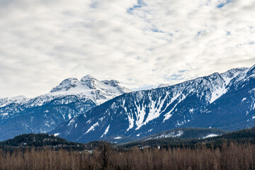 Fototapeta premium huge mountains covered by snow and sunny sky with clouds british columbia canada