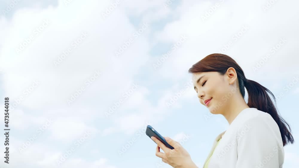 Aufkleber 青空を背景にスマホで通話する女性