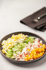 Salad of crab sticks, cucumbers, eggs and corn. Russian festive food