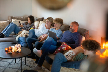 Smiling family sitting on sofa in living room at home