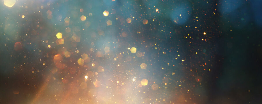 background of abstract glitter lights. gold, blue and black. de focused
