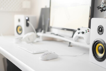 Fototapeta na wymiar White modern wired gaming mouse in a white comfortable gamer workspace. Close-up of a special device