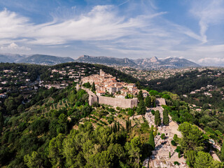 Fototapeta na wymiar Drone shot from Saint-Paul-de-Vence. Medieval fortified village in the south of France. The narrow picturesque streets of the village. Stone facades of the 16th-18th centuries. Green Hills. Chapel