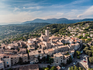 Fototapeta na wymiar Drone shot from Saint-Paul-de-Vence. Medieval fortified village in the south of France. The narrow picturesque streets of the village. Stone facades of the 16th-18th centuries. Green Hills. Chapel