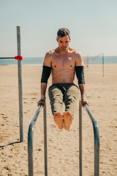 Gymnastic balancing on parallel bars at beach