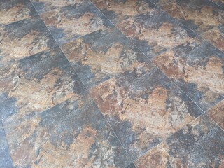 A beautiful shiny floor tiles with black and orange-colored abstract designs. 