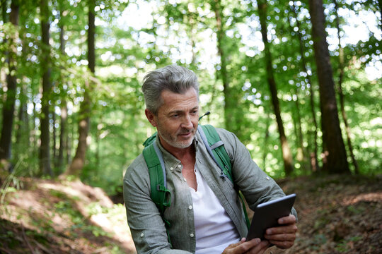 Male hiker using digital tablet in forest