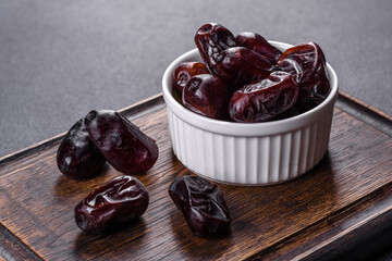 Beautiful delicious dates on a dark concrete background