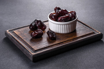 Beautiful delicious dates on a dark concrete background