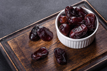 Beautiful delicious dates on a dark concrete background