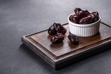 Beautiful delicious dates on a dark concrete background