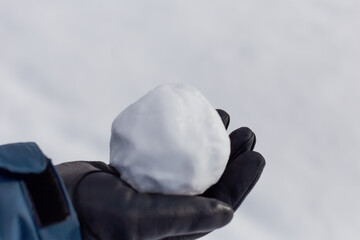 Snowball in a man's hand in a glove