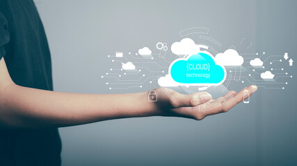 Fototapeta premium Cloud technology,Technology transformation, Data security concept. Businessman hold digital cloud downloading and uploading data application with cloud icons and circuit boards in the background.