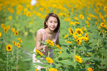 Asian woman at sunflower field portrait outdoor.