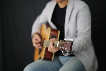 Portrait of men musician playing guitar in studio.