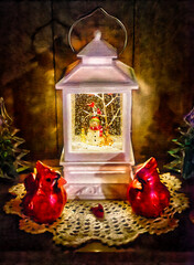 A white lantern snowglobe with snowman and cardinal inside.  Cardinals and glass Christmas trees on...