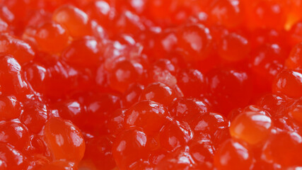 Red caviar. Bright background or backdrop. Wallpaper for a desktop with an aspect ratio of 16 to 9. Macro. Selective focusing